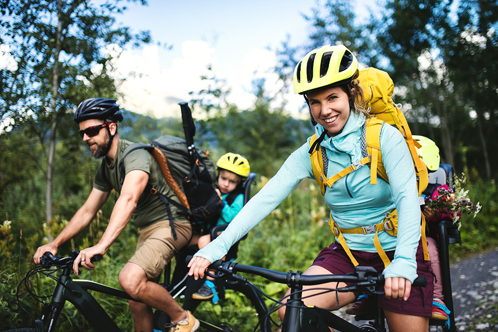 Family with small children cycling outdoors in summer nature, High Tatras in Slovakia.
